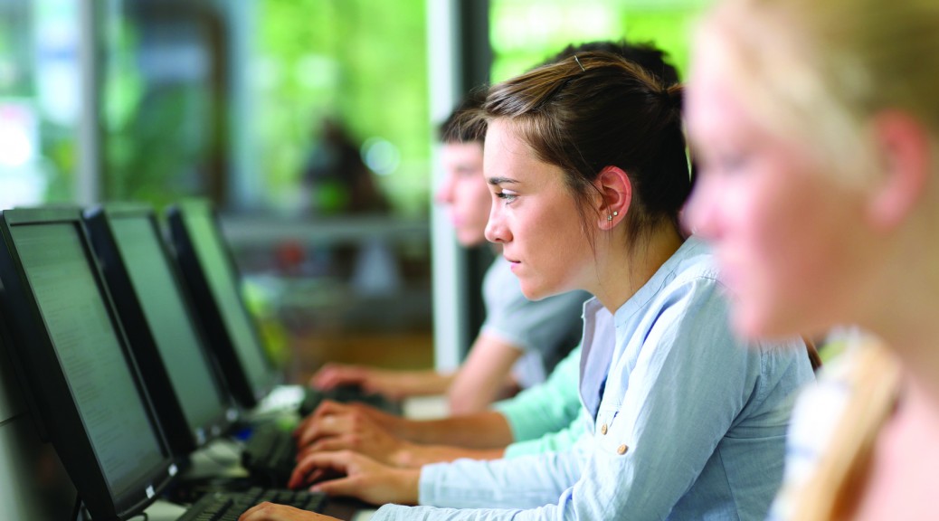 Students in class working on desktop computer